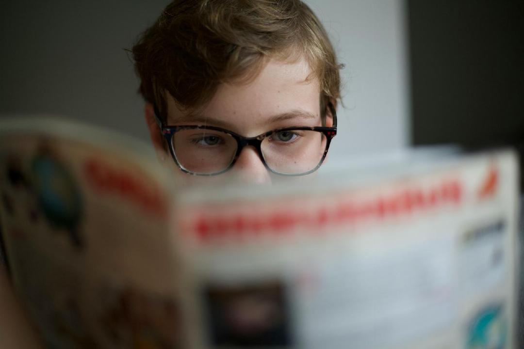 un enfant lisant un magazine