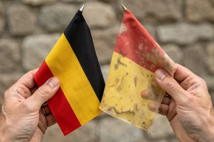 Comparaison côte à côte d'un drapeau noir jaune rouge officiel et d'une copie, mettant en évidence les différences de couleur et de qualité de couture