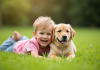 Enfant riant allongé sur l'herbe avec un chiot labrador